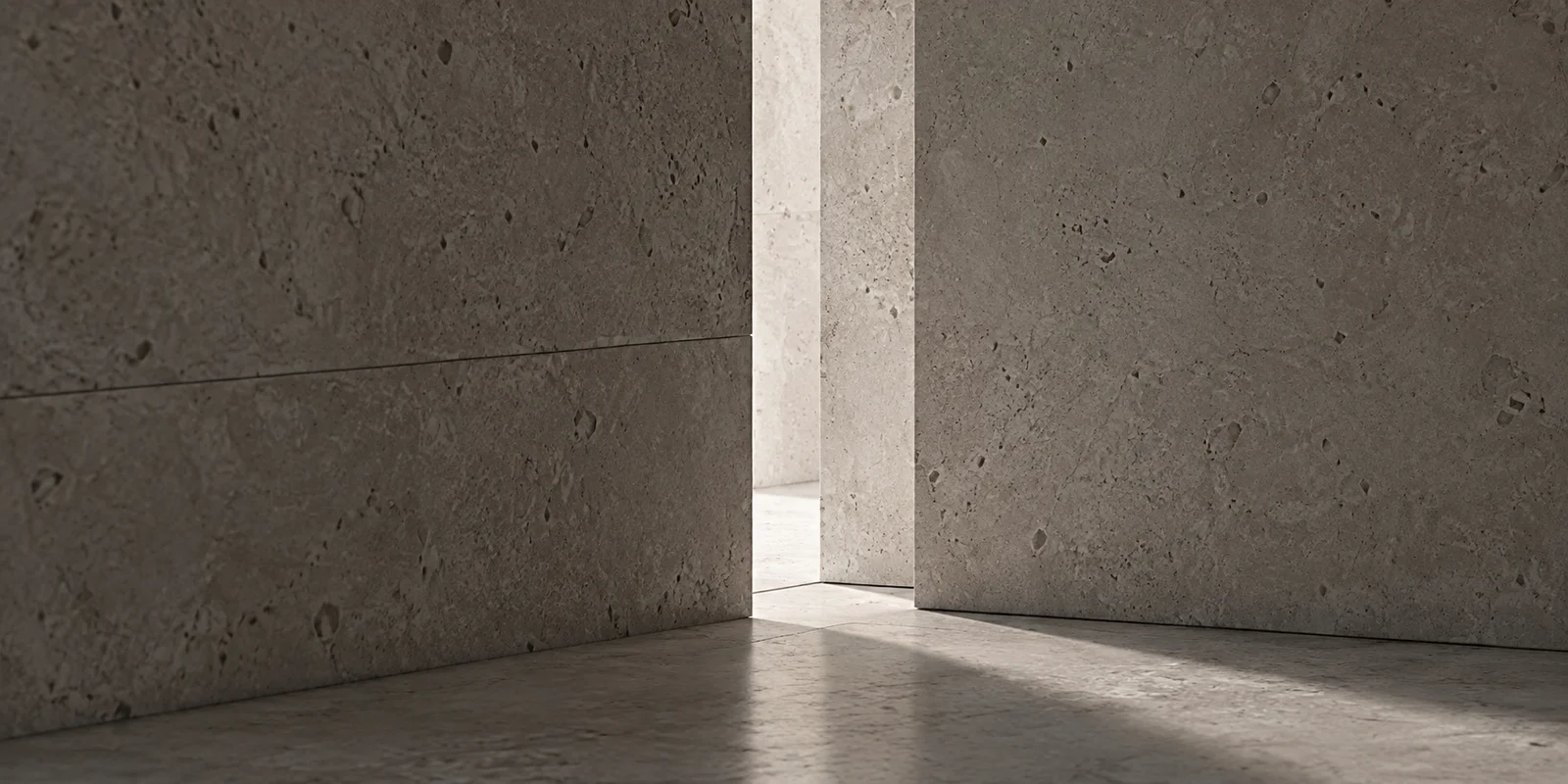 A narrow opening between two textured stone walls, lit by soft daylight.